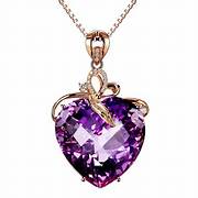 A heart-shaped amythest stone, set in gold with a swirling gold design at the top. and hanging on a delicate gold chain